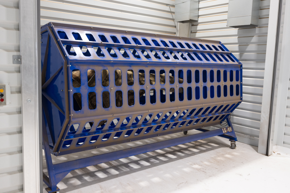 Blue industrial rotating drum machine in metal room