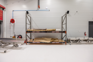 Industrial shelving labeled dirty rugs with rolled carpets